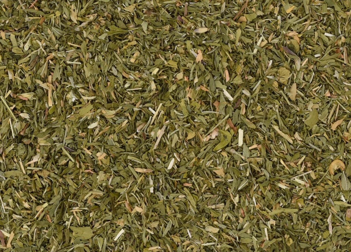 Close-up of dried alfalfa herb, showing chopped green leaves used for teas and herbal remedies.