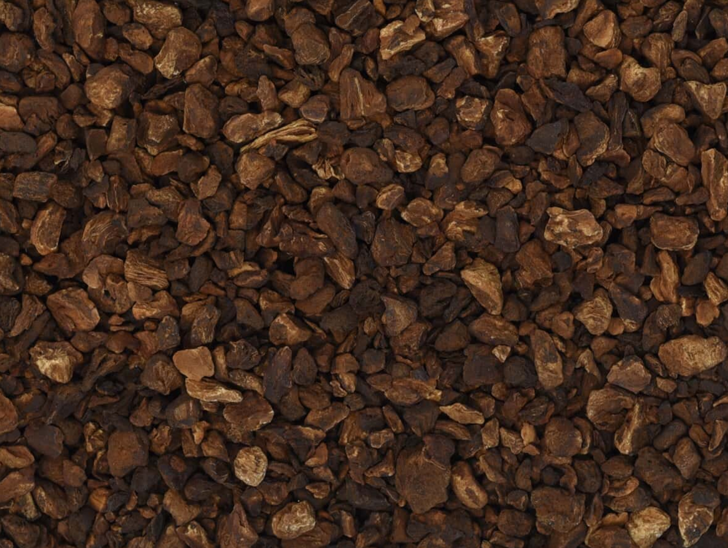 Close-up texture of dried chicory root, showing dark brown root pieces used for teas and herbal remedies.