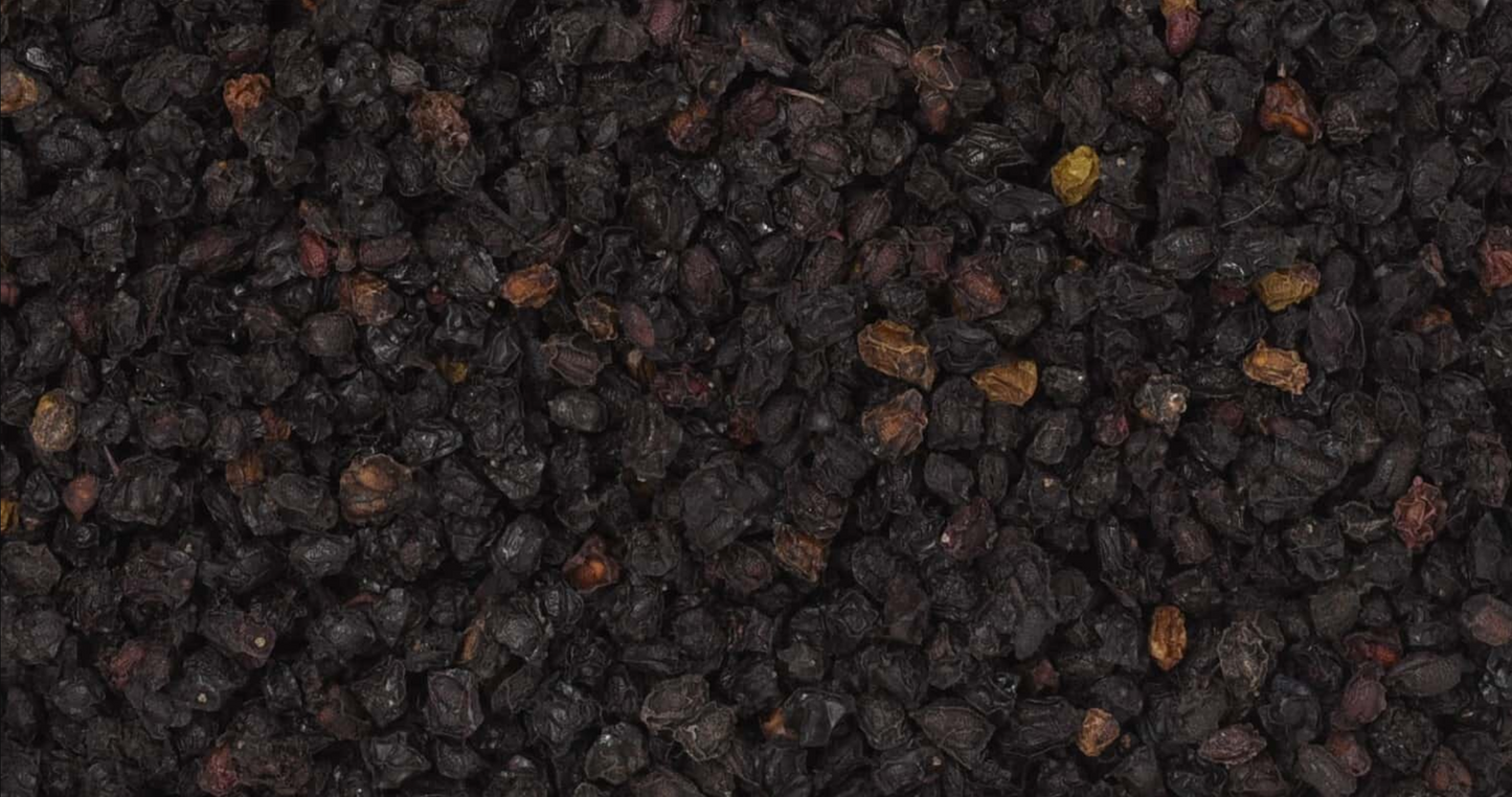 Close-up of dried elderberries, showing small dark purple berries used for teas and herbal remedies.