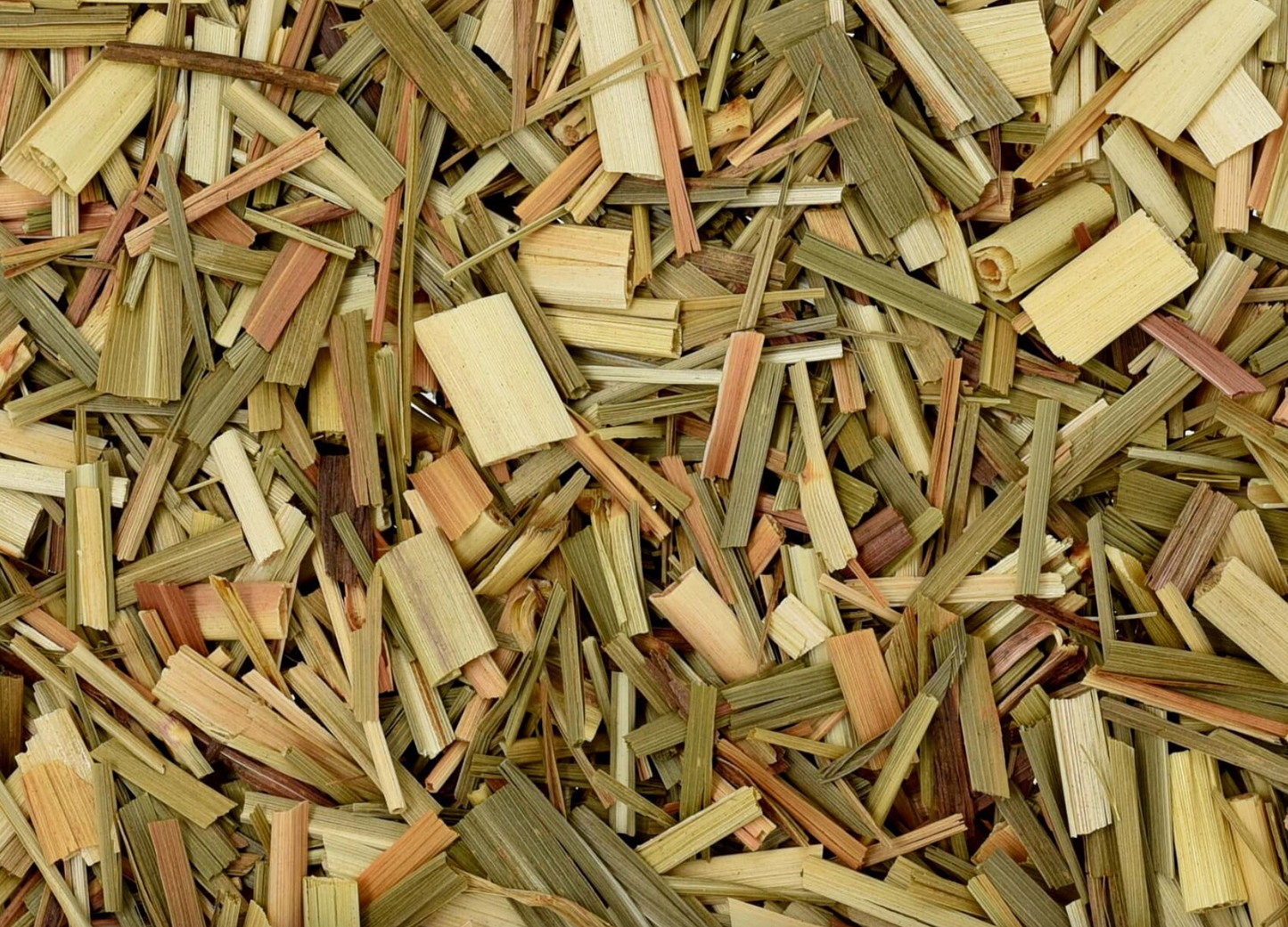 Close-up of dried lemongrass, showing chopped green pieces used for teas and herbal remedies.
