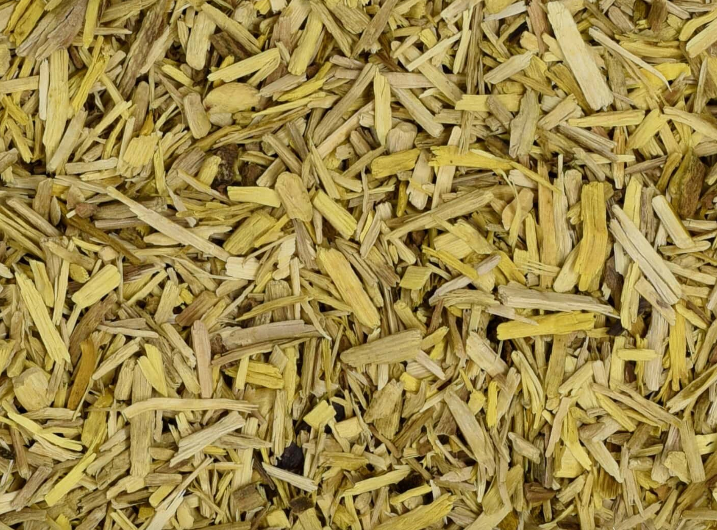 Close-up of dried oregon grape root, showing finely cut yellow root used for teas and herbal remedies.