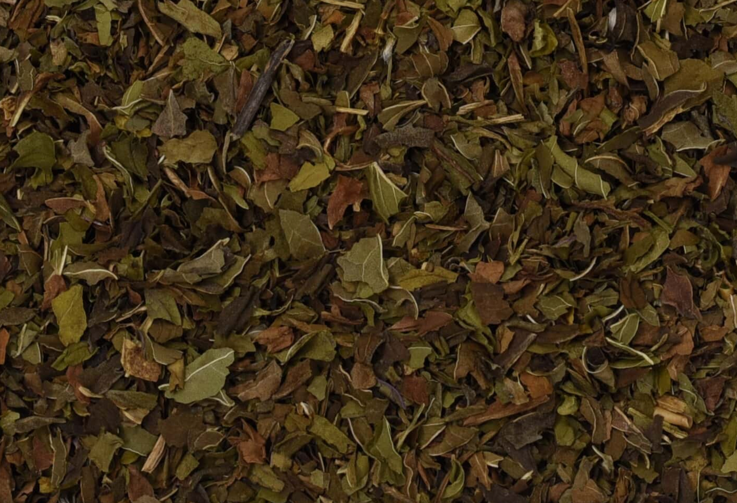 Close-up of dried peppermint herb, showing chopped dark green leaves used for teas and herbal remedies.