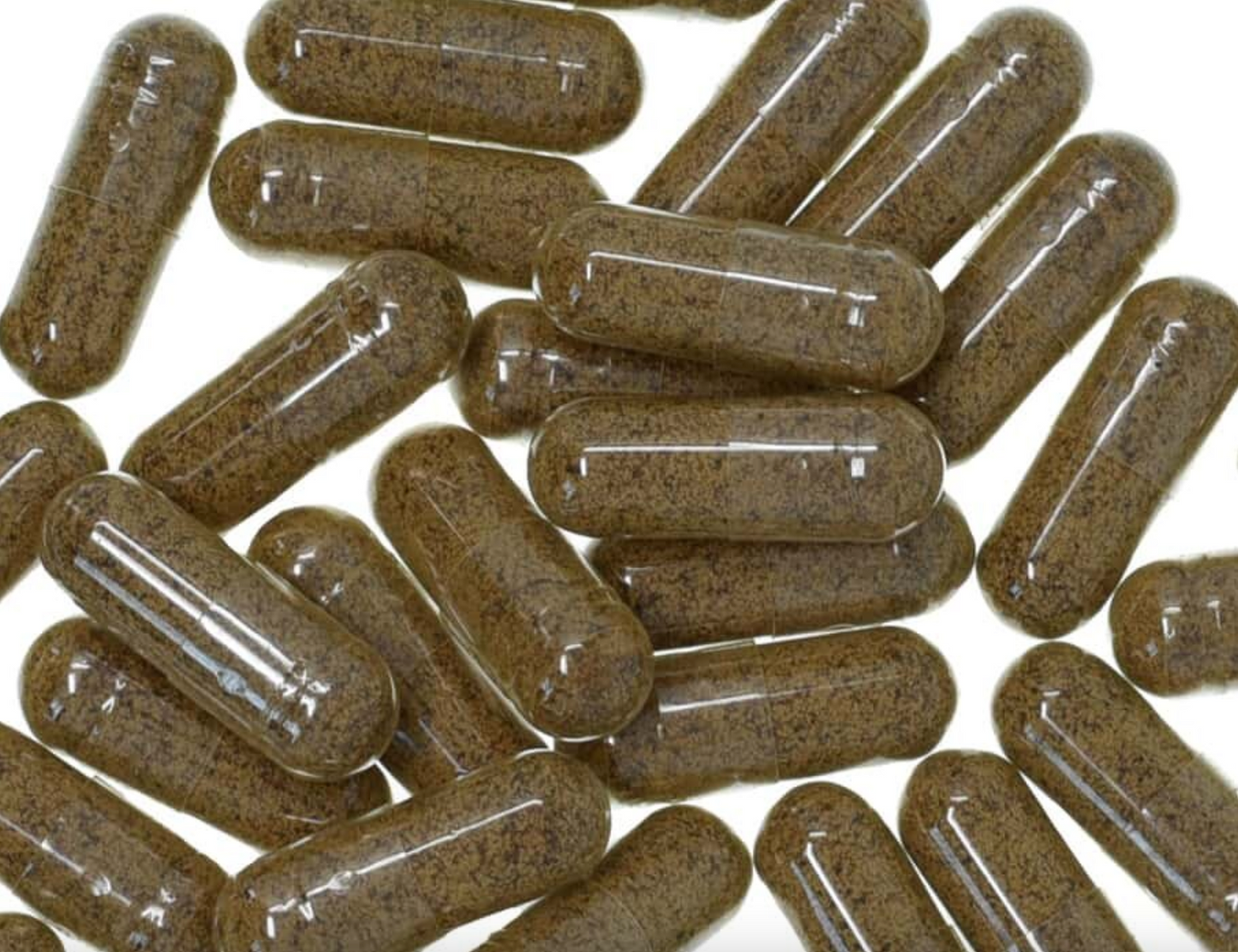 Turkey tail mushroom capsules with clear glossy shells, filled with brown powder, used for natural health and wellness.