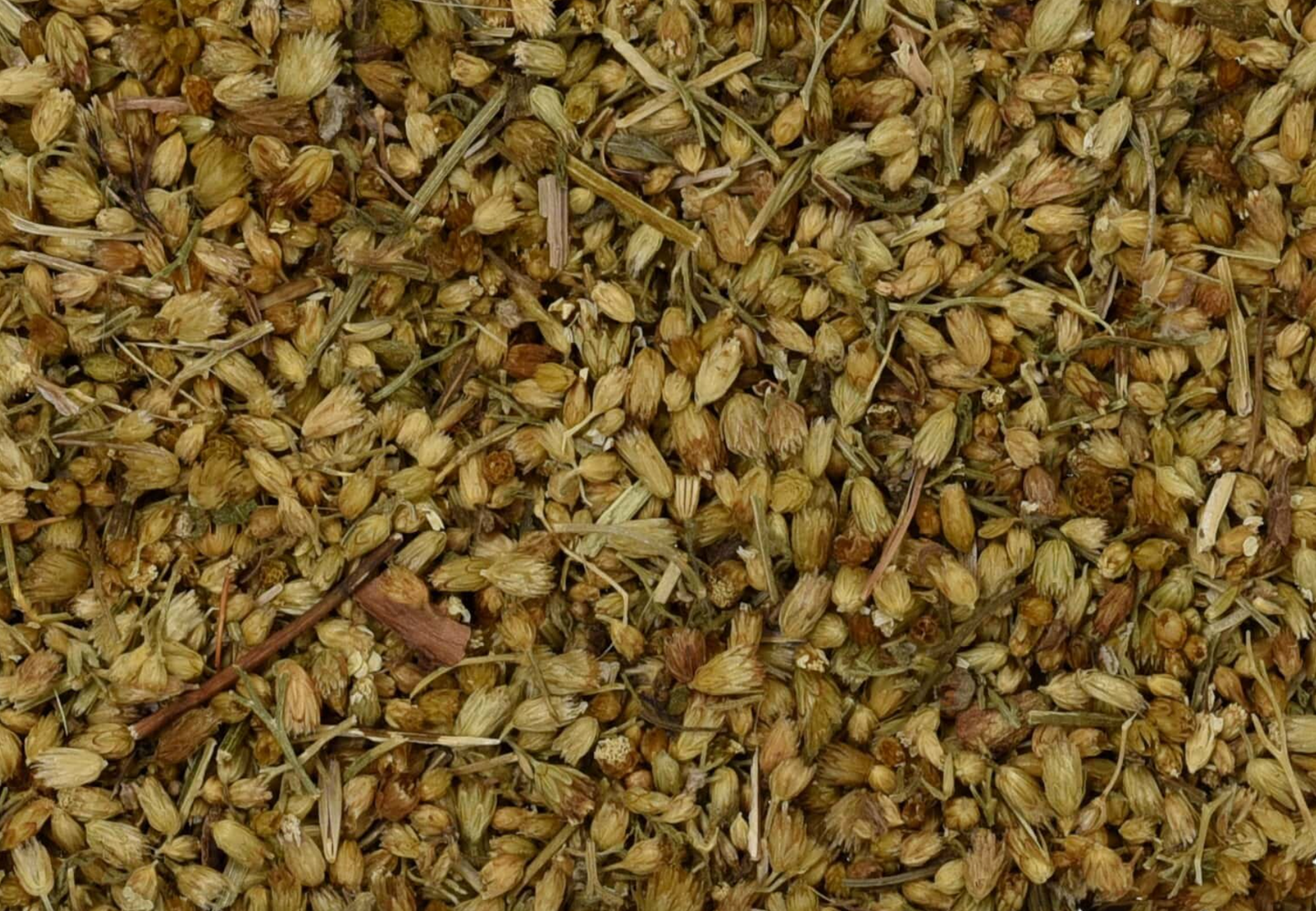 Close-up of dried yarrow herb, showing chopped yellow flowers and pieces used for teas and herbal remedies.
