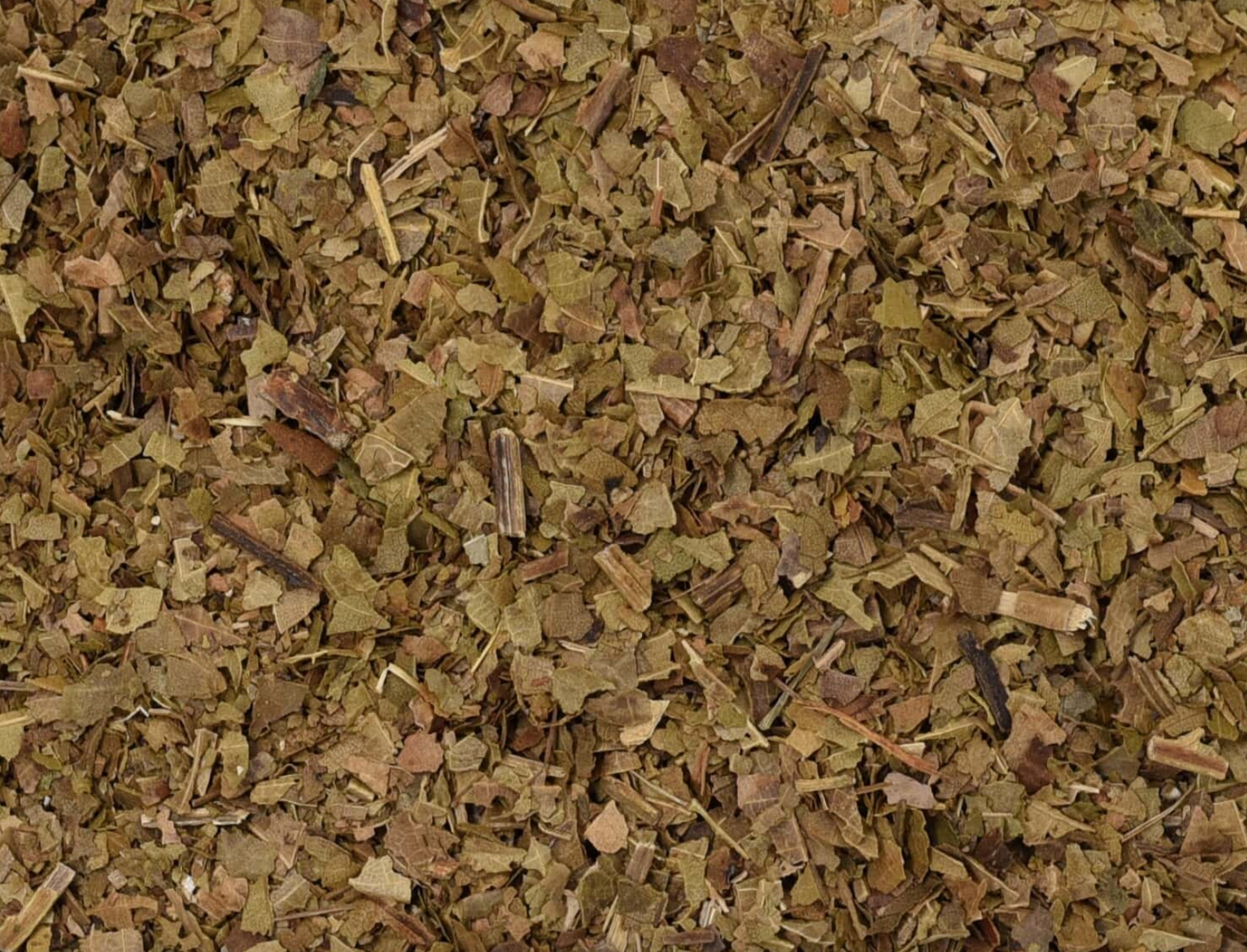 Close-up texture of dried black walnut leaf herb, showing chopped leaves used for teas and herbal remedies.