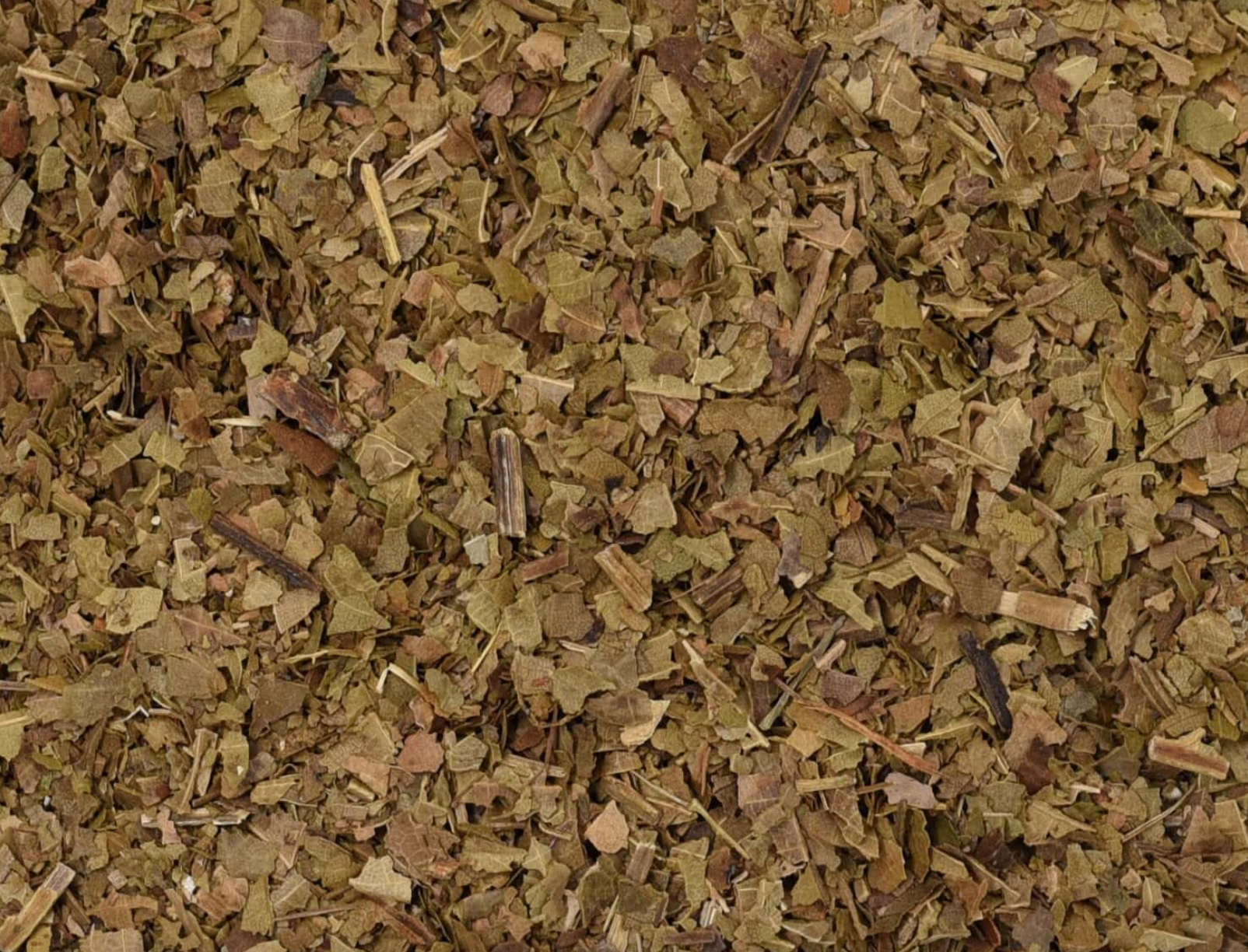 Close-up texture of dried black walnut leaf herb, showing chopped leaves used for teas and herbal remedies.