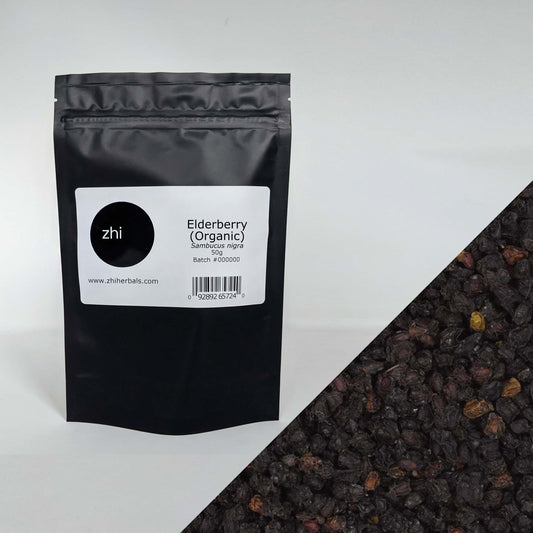 Zhi Herbals Organic Elderberry, 50g black package with label, next to a close-up of the dark purple berries.